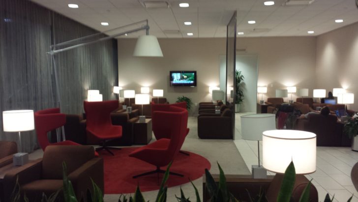 a room with red chairs and a television