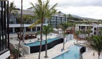 a pool and palm trees in front of a building
