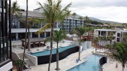 a pool and palm trees in front of a building