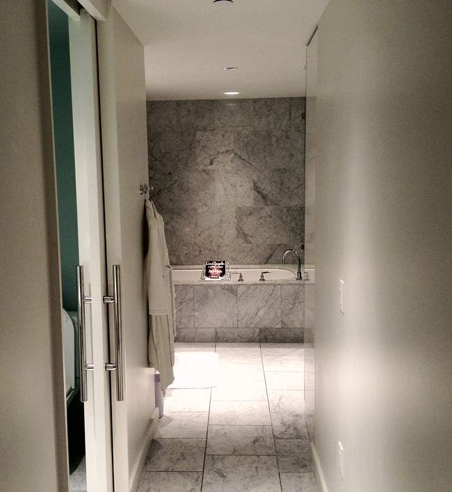 a bathroom with marble walls and a bathtub