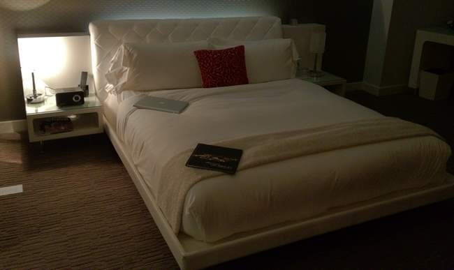a bed with a book and a lamp