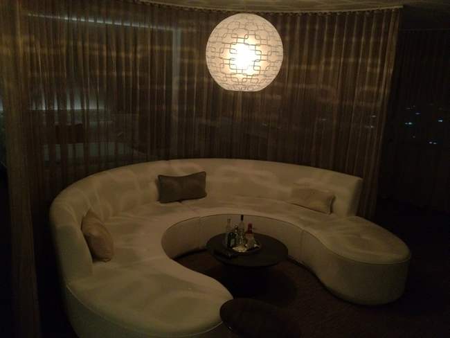 a round white couch with a round light fixture