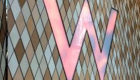 a pink letter on a tile wall
