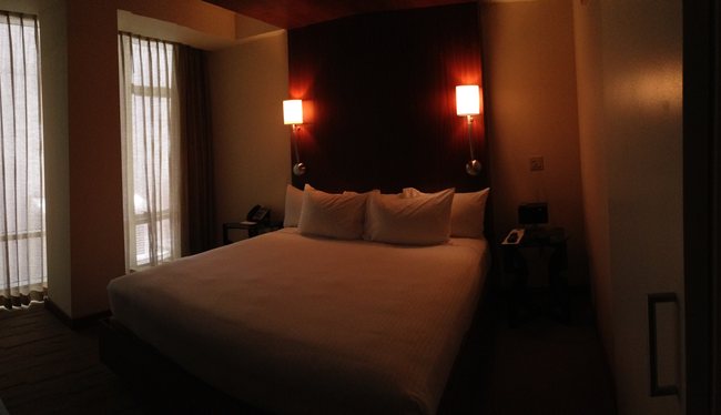 a bed with white sheets and pillows