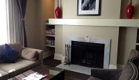 a living room with a fireplace and a picture of a man
