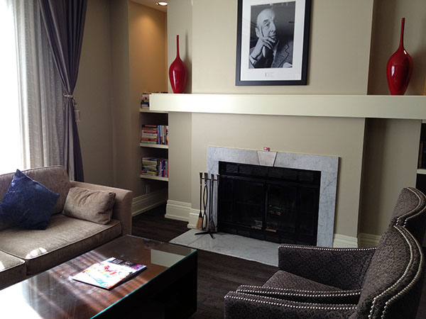 a living room with a fireplace and a picture of a man