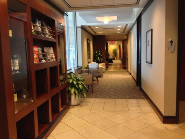 a hallway with a bookcase and chairs