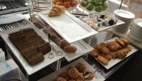 a buffet table full of pastries and fruits