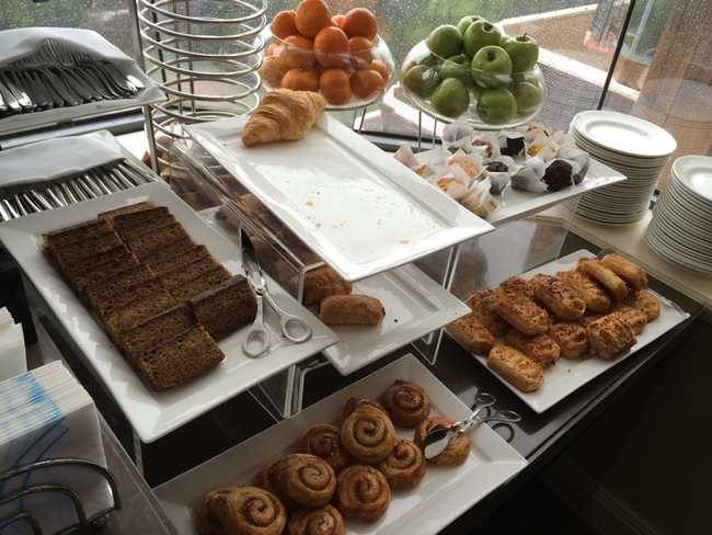a buffet table full of pastries and fruits