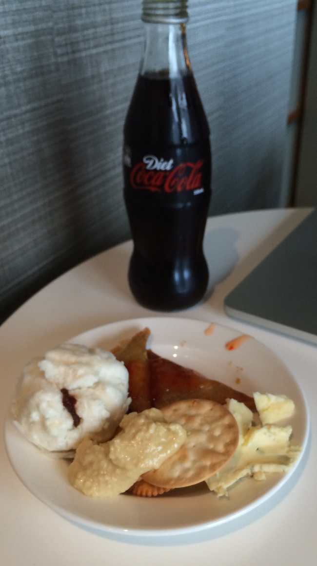a plate of food and a soda bottle
