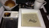 a plate of soup and bread on a tray