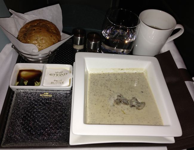 a plate of soup and bread on a tray