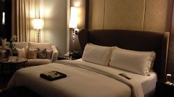 a bed with pillows and a chair in a room