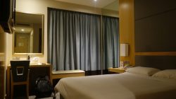 a hotel room with a bed and a mirror