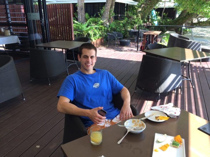 a man sitting at a table with food and drinks