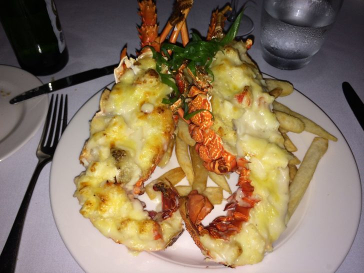 a plate of lobster with french fries and a fork and knife