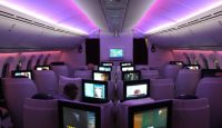 a group of people sitting in a row of seats with monitors