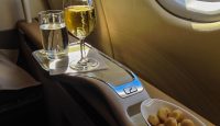 a pair of wine glasses and a bowl of snacks on a table