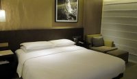 a bed with white sheets and a picture on the wall