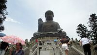 a large statue of a buddha with Lantau Island in the background