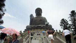 a large statue of a buddha with Lantau Island in the background