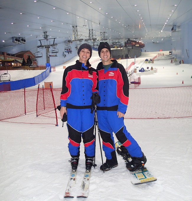 a man and woman in snow gear standing on skis