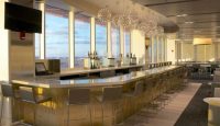 a long bar with chairs and a television