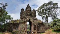 a stone structure with a man walking by
