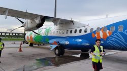 a woman standing next to an airplane
