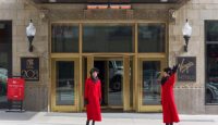 two women in red coats outside of a hotel