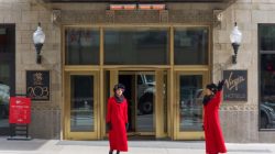 two women in red coats outside of a hotel