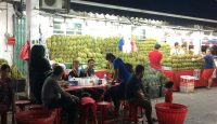 a group of people sitting at a table outside a market