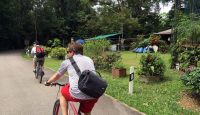 a man riding a bicycle on a path with other people