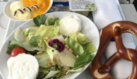 a bowl of salad and pretzel on a tray