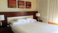 a bed with white sheets and a lamp