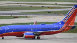 a blue and red airplane on a runway