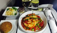 food on a tray with glasses and a drink