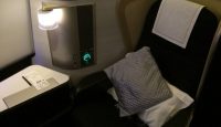 a seat with pillows and a lamp on the side