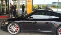 a black sports car parked in front of a building