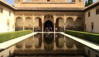 a pool of water in front of Alhambra