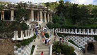a group of people walking up stairs in front of Park Güell