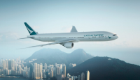 a large white airplane flying over a city