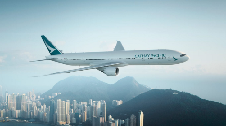 a large white airplane flying over a city