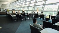 people sitting in a room with many windows