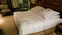 a bed with white sheets and a robe on it