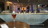 a glass of wine on a table in a room with a bar