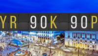 a digital sign with numbers and buildings in the background