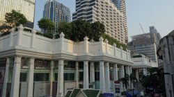 a building with columns and trees in front of it