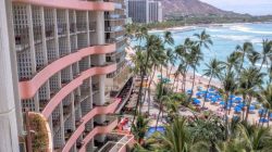 a building with palm trees and a beach
