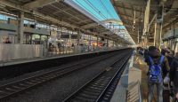 a train station with people waiting for the train